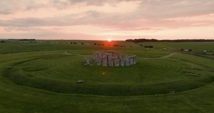 Drone flies around the iconic Stonehenge stones during breathtaking pink sunset