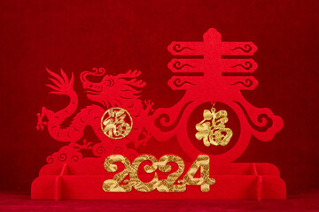 Chinese New Year of Dragon mascot paper cut on red background English translation of the Chinese...