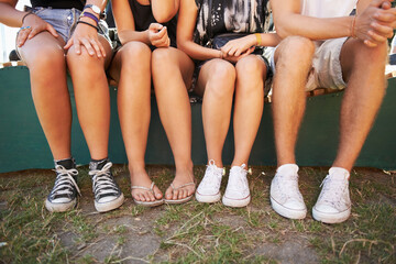 Legs, feet and friends outdoor at a music festival together for social gathering at a concert or...