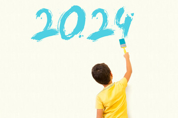 Cute little boy drawing new year 2024 with painting brush on wall background
