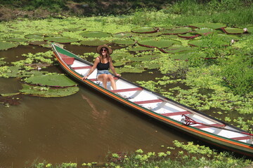 mulher sentada em barco rodeado por vitórias régias no Rio Croa, em Cruzeiro do Sul, Acre 