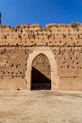 Photo of a large door of the El Badi palace in the city of Marrakech on a sunny day.