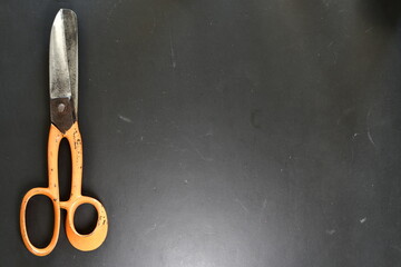 Scissor on Black desk Background Steel Orange