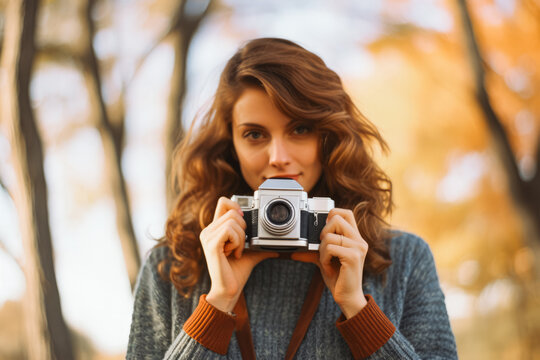 Portrait of a beautiful red-haired girl in a hat with a vintage camera. Retro camera photographer close up. Photography.