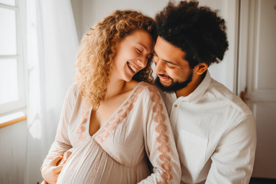 Man and woman smiling and being happy because they will get a baby. Pregnancy, hugging. Mixed race. Support and love.