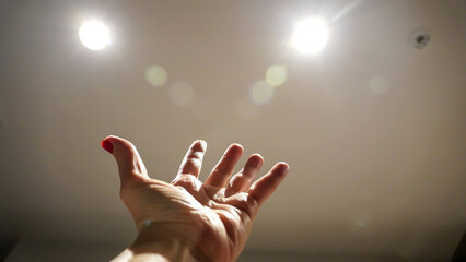 Woman's dramatic hand gestures with a light on an isolated background