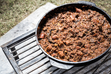 Salsa a la parrilla de salchichas y carne picada, cocinandose a las brasas, al aire libre