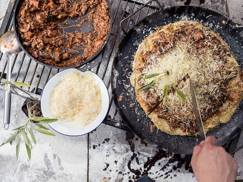 Cortando pasta a la parrilla con salsa y queso