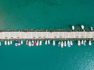 boats in the harbor in the city of kalamata greece, drone shot above the sea