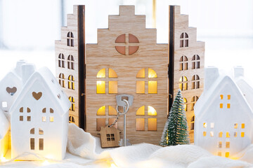 Key and tiny house of a small size on cozy home with Christmas decor on window sill. Gift for New...