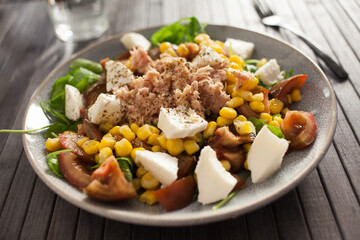 Plate of salad with tuna, corn, tomatoes and arugula