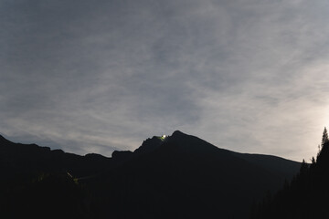 Night scene in the Polish Tatra Mountains, clouds illuminated by moonlight.