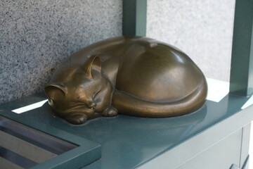Bronze statue of a sleeping cat in a Japanese garden