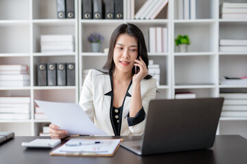 Confident Asian Businesswoman Talking on Phone in Modern Office. Corporate Communication and Technology Concept