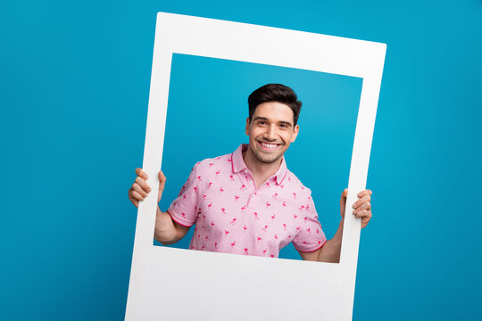 Portrait of nice cheerful young man hands hold paper album set card isolated on blue color background