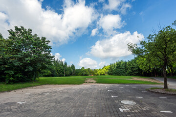Blue sky, white clouds, grass, and trees in the city park