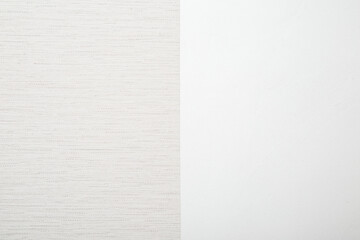 New light gray wallpaper on white wall background. Two sides. Closeup. Repair work of home. Front...