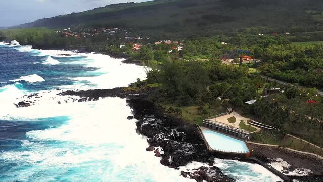 Aerial drone view of Puits des Anglais with an empty pool, natural pool and high breaking waves, Saint-Philippe, Reunion.