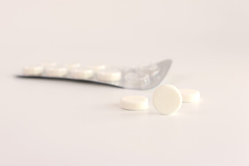 A pack of white pills on a white background. Medicine and health care.