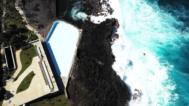 Aerial drone view of Puits des Anglais with an empty pool, natural pool and high breaking waves, Saint-Philippe, Reunion.