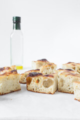 homemade olive focaccia on a white background, Flatlay of focaccia with green olive topping, fresh homemade focaccia bread
