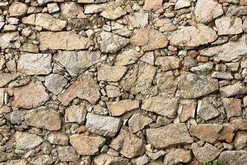 a yellow beige natural stone wall of different sized stones, traditional crafts