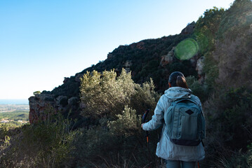 Woman contemplates the landscapes of the Garraf Natural Park while walking the paths of a mountain.