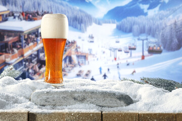 Fresh cold beer in glass and snow decoration. Background of table cover of frost and snow....