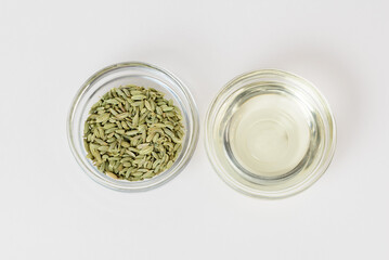 Fennel organic oil and fennel seeds  in glass bowls isolated top view