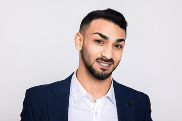 Turkish guy with white teeth beautiful smile standing over white background in studio laughing having great fun.