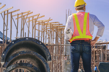 Smart civil architect engineer inspecting and working outdoors building side with blueprints. engineering and architecture concept.