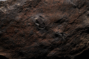 Brown stone texture, dark abstract background. Natural mineral rock close up details, empty backdrop with copy space for design