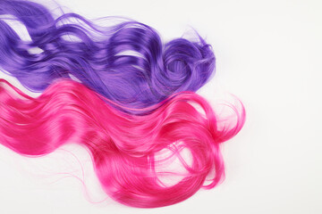 Natural looking shiny hair of different bright colors, cosplay wig on a white background