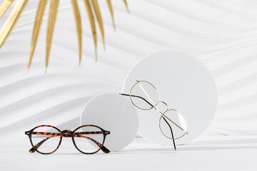 Two pairs of eyeglass frames on white background. Minimalism, eyewear fashion concept. Trendy eyeglasses still life in minimal style. Optic store discount, sale, promotion. Copy space for text - obrazy, fototapety, plakaty