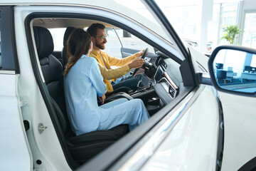 Naklejka premium Photo of happy couple in car showroom