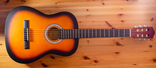Musical instrument guitar on wooden background