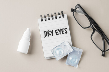 Dry eyes concept with contact lens, eye drop bottle and eyeglasses on beige background