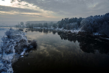 floes on the Warta River and snow-covered bushes and trees during winter - obrazy, fototapety, plakaty