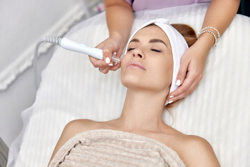 cosmetologist making procedure microdermabrasion on the face in beauty salon. professional skin care