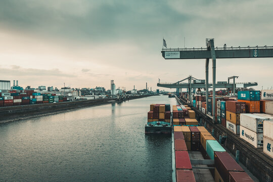 Mannheim, Germany - 26.03.2021: Freight containers at the container terminal of the inland port of Mannheim and industrial area of Ludwigshafen in the background.