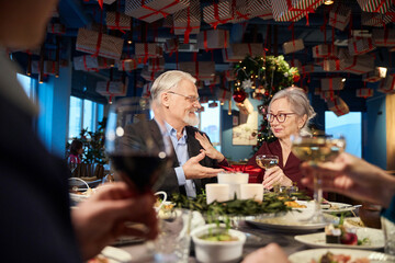 Cheerful aged man and woman celebrating New Year enjoying party
