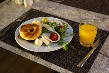 Everyday European breakfast bun egg cheese toomat greens olives.,