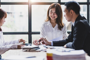 Happy Asian businesswoman meeting with colleagues in office.