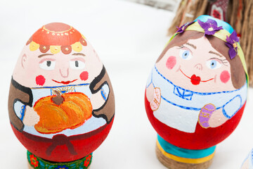 Obraz premium two eggs painted with bright colors in the form of peoples faces.