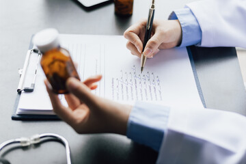 The doctor is writing a prescription. Doctor giving healthcare and medicine advice to patient in...