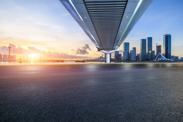 Asphalt road and bridge with city skyline at sunset in Zhuhai, Guangdong Province, China.