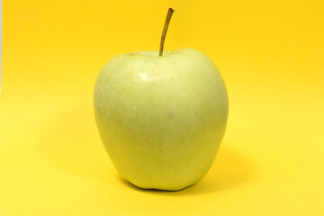 Green apple on a yellow background
