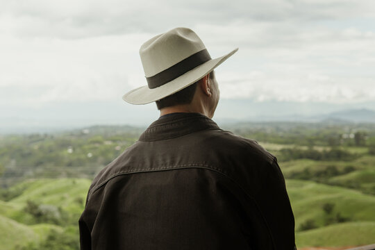 back portrait of a man dressed in black on a lookout point wearing a Colombian hat