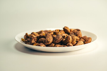 Close up of roasted cashew nuts with skin on white background