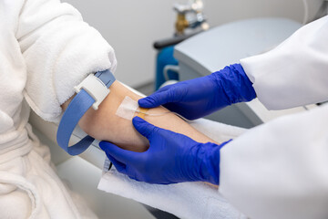 Woman receiving intravenous vitamin therapy in wellness center or beauty salon sitting in armchair.